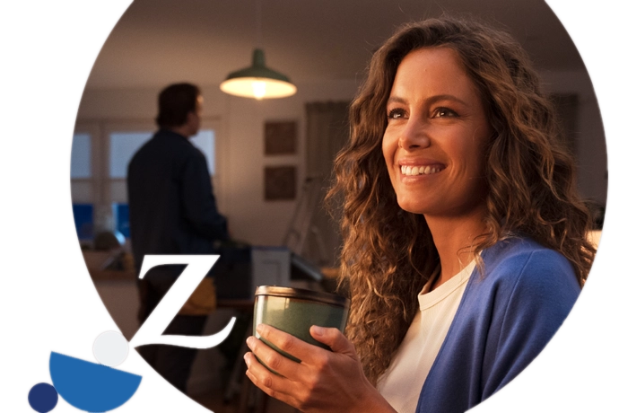 Laura Madrueño en casa con una taza y  con un operario de fondo