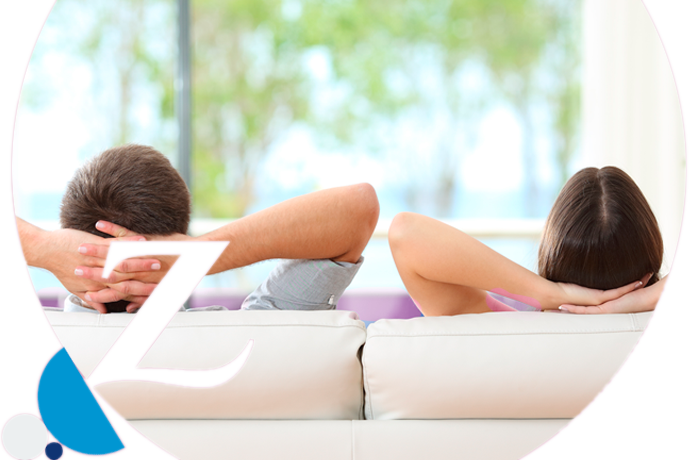 pareja relajada en el sofá con las manos apoyadas en la cabeza