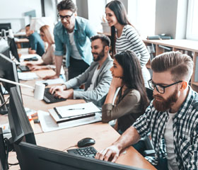 Diferentes trabajadores con ordenadores en una oficina 