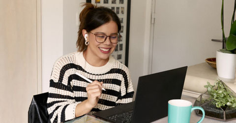 chica sonriente delante de un ordenador portátil