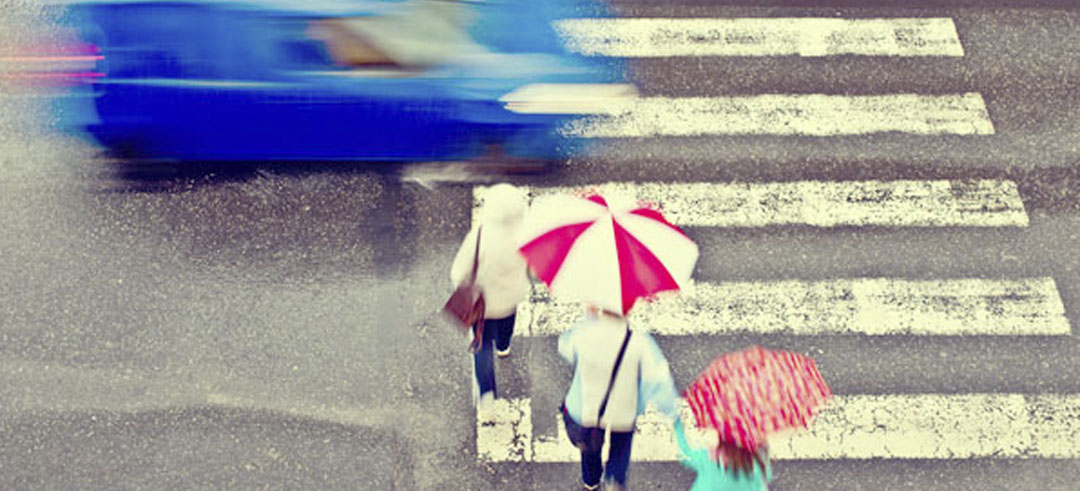 Paso de peatones con tres persona y un coche cruzando